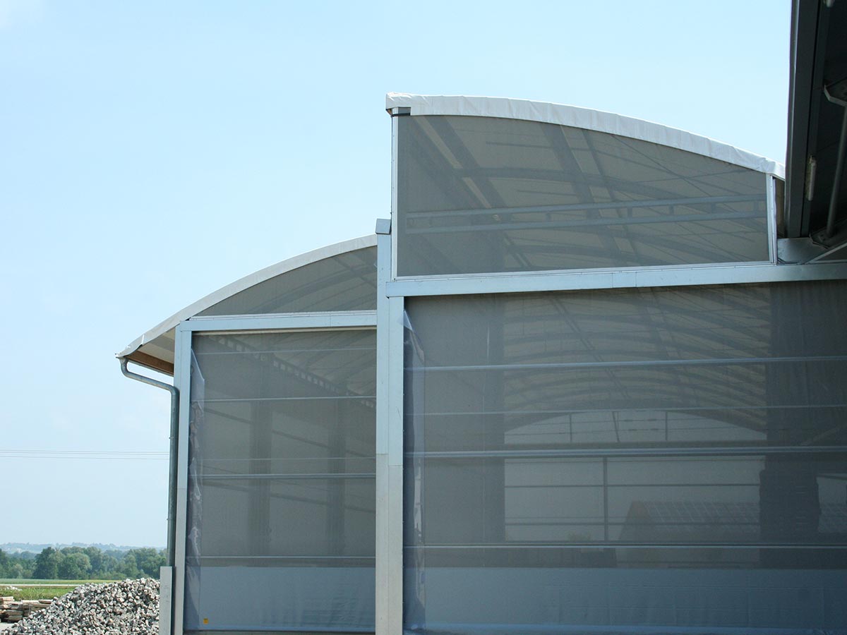 Giebel und Rolltor aus transparentem Windschutznetz an Logistikhalle