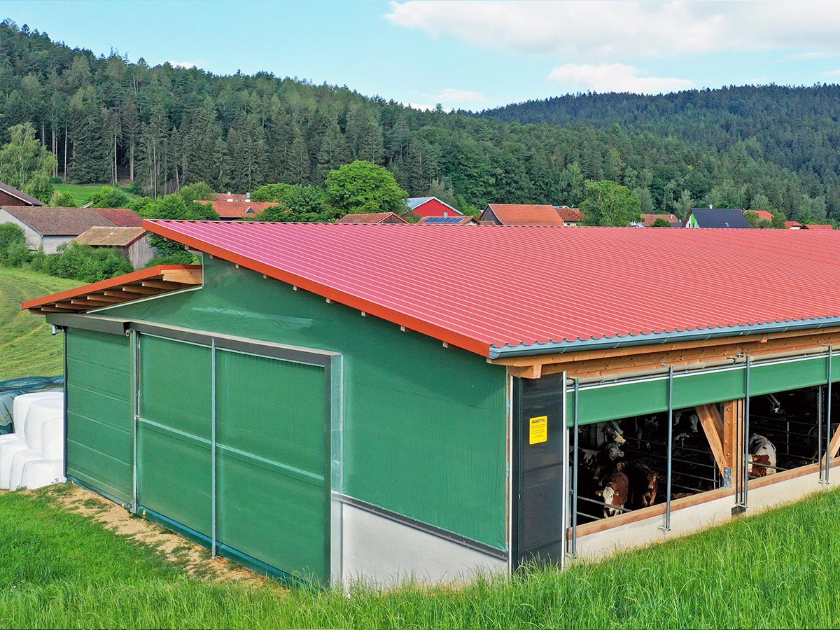 Tierwohl Rinderhaltung: Rinderstall mit Windschutznetz, Toren und aufrollbarem Curtainsystem