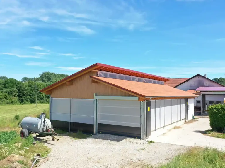 Kälberstall mit Windschutz-Rolltoren zur natürlichen Belüftung und einfachen Bewirtschaftung