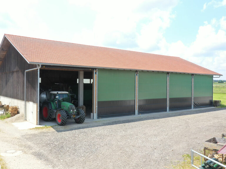 Elektrische Rolltore WST9 an Lager- und Maschinenhalle. Gefertigt aus Windschutznetz und Plane