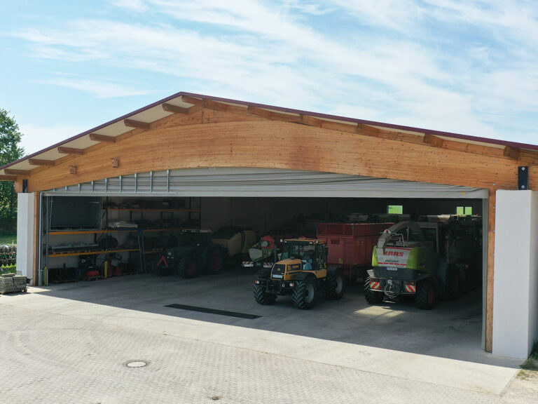 Großes Windschutztor für Maschinenhalle mit Traktoren und Feldhäckslern