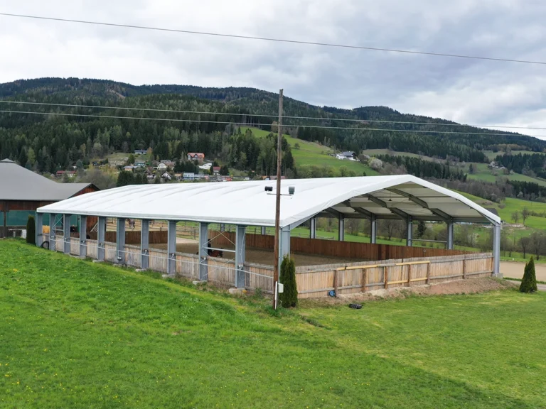 Reiterin trainiert in neuer offener Reithalle