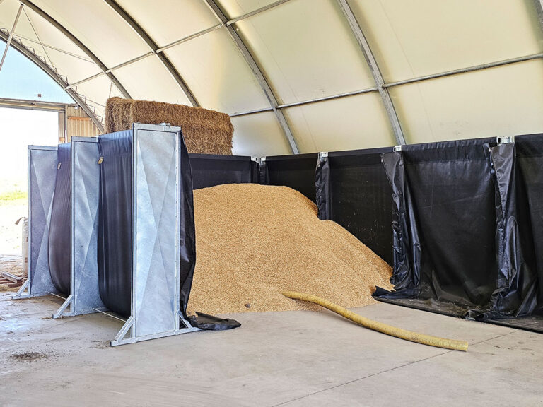 TexWall Schüttgutwände in einer Lagerhalle, befüllt mit Getreide. Das mobile System ist ohne Bodenverankerung aufgestellt und flexibel einsetzbar.