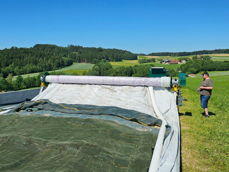 Silo Schani beim Abrollen der Plane und automatischen Beschweren des Fahrsilos