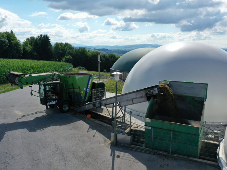 Substrat (Silo) wird von Futtermischwagen auf Förderband geleert und in den Fermenter befördert.